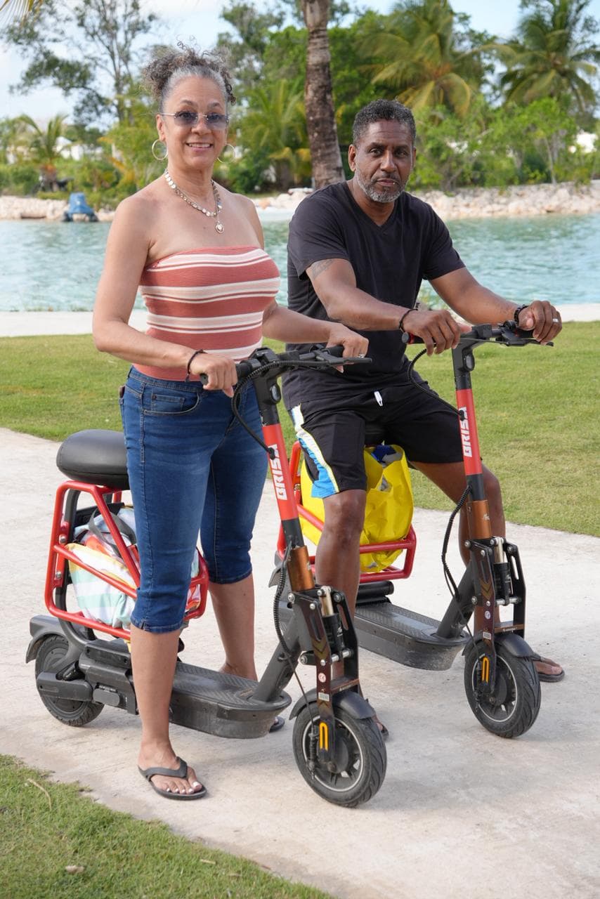 Couple enjoying Brisa Ride electric scooters by Vista Cana's waterfront