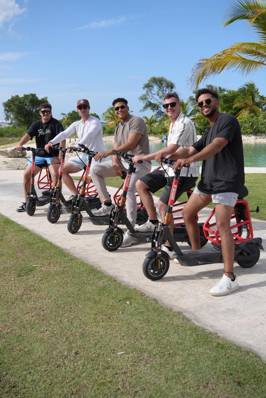 Group of Brisa Ride riders lined up by Vista Cana's lakefront with palm trees